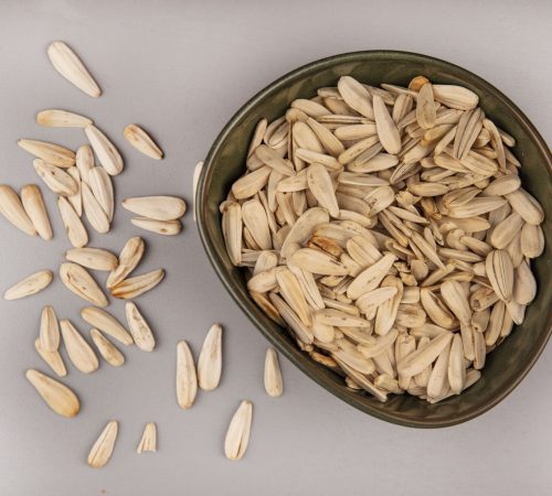 top-view-tasty-white-sunflower-seeds-bowl-with-sunflower-seeds-isolated